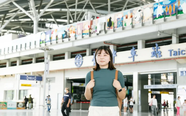 學生背著背包站在火車站大廳